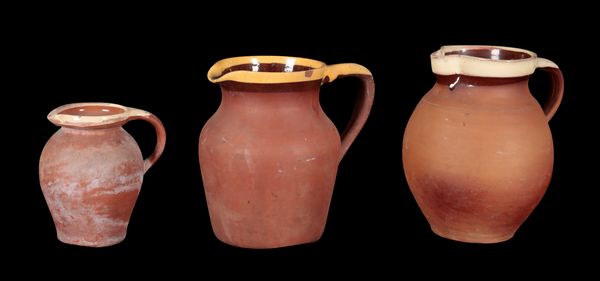 A GROUP OF THREE GRADUATED TERRACOTTA JUGS