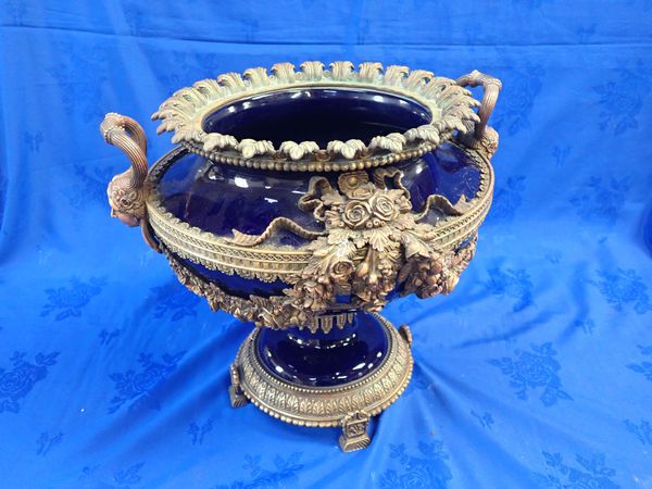 A LARGE LOUIS XV STYLE GLAZED CERAMIC AND CAST BRASS URN