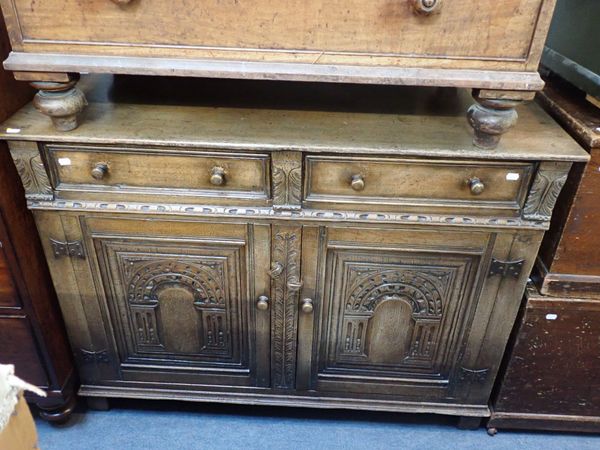 AN OAK SIDEBOARD WITH CARVED ARCHED PANEL DOORS