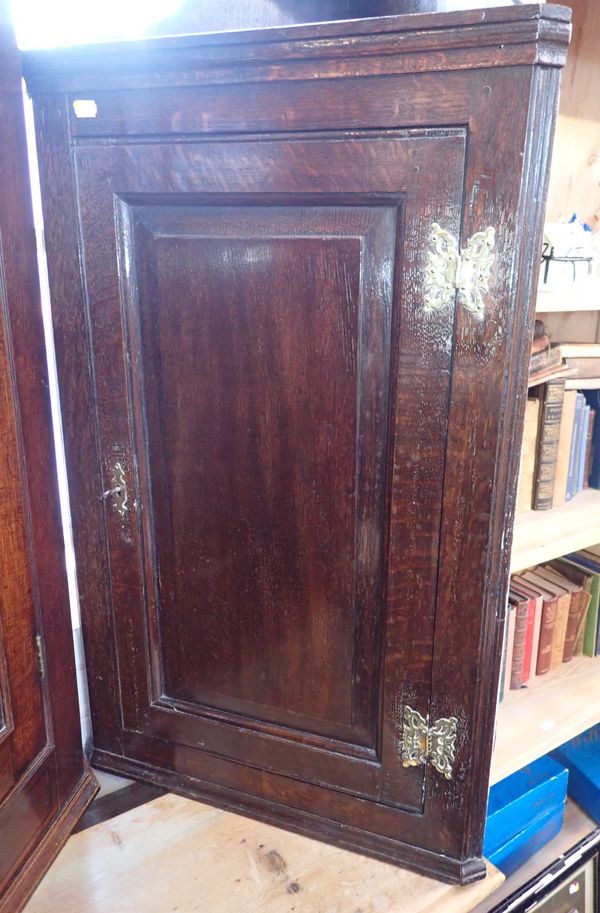 A SMALL GEORGE III OAK HANGING CORNER CUPBOARD