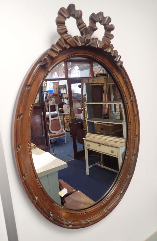 AN EDWARDIAN WALNUT FRAMED OVAL WALL MIRROR