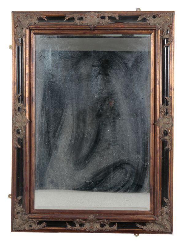 AN EBONISED AND PARCEL GILT MIRROR
