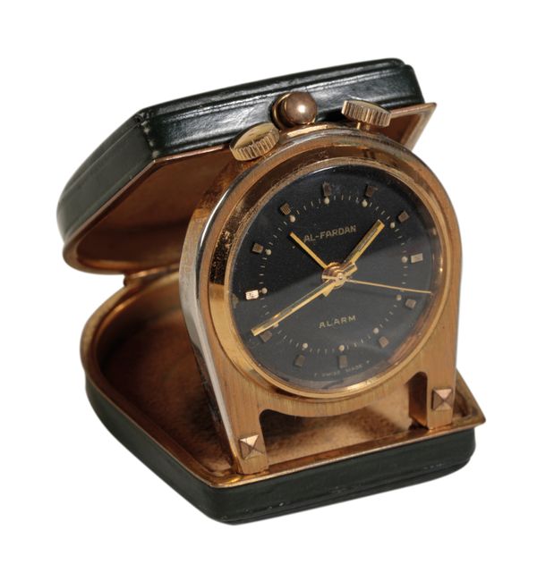 AL-FARDAN: A MINIATURE BRASS PURSE ALARM CLOCK