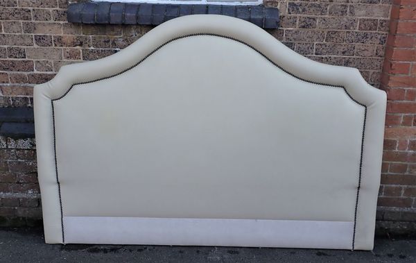 A WHITE LEATHERETTE UPHOLSTERED HEADBOARD