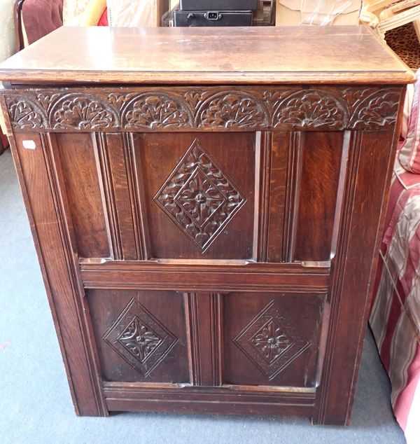 A CARVED OAK CUPBOARD