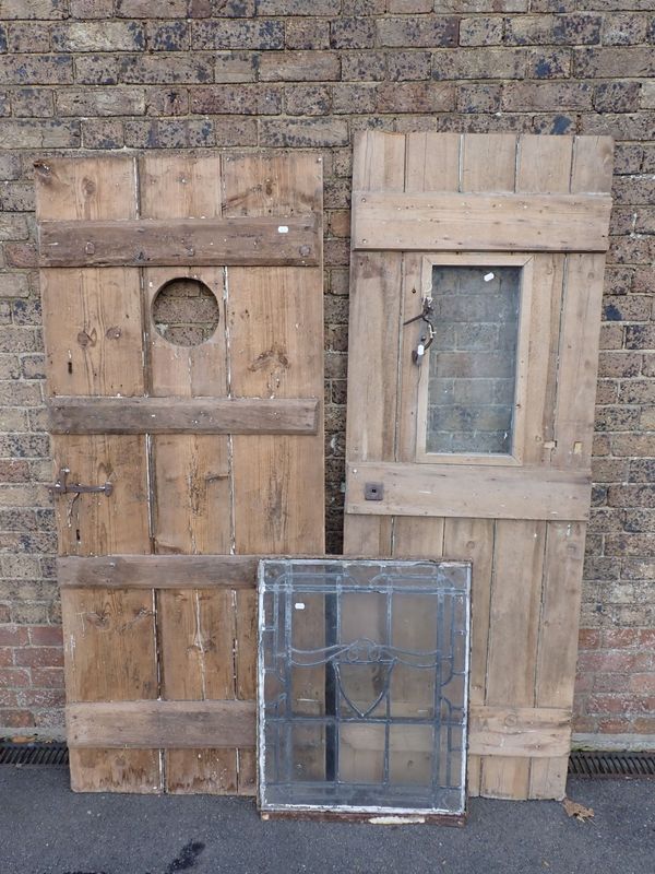 A LEDGED DOOR, OF THREE WIDE BOARDS WITH ROUND  APERTURE