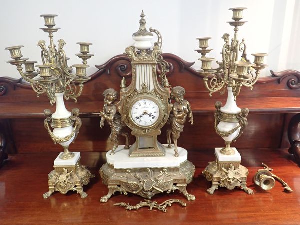 A 20TH CENTURY ITALIAN POLISHED BRASS AND CARRERA MARBLE CLOCK GARNITURE