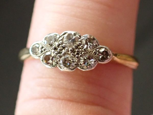 AN 18CT GOLD AND DIAMOND EIGHT STONE ENGAGEMENT RING