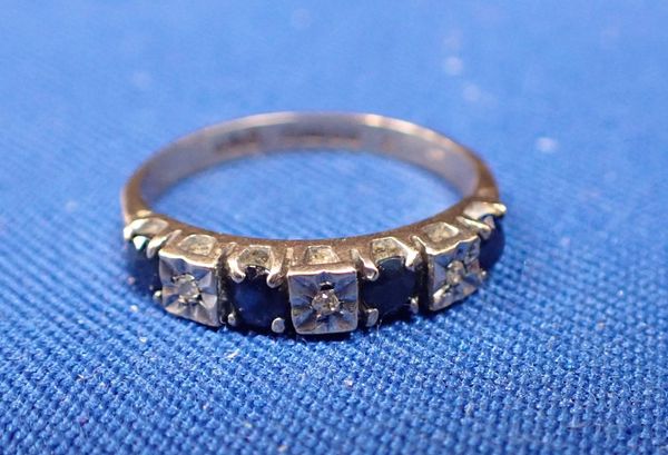 A 9CT GOLD, SAPPHIRE AND ILLUSION SET DIAMOND SEVEN STONE RING