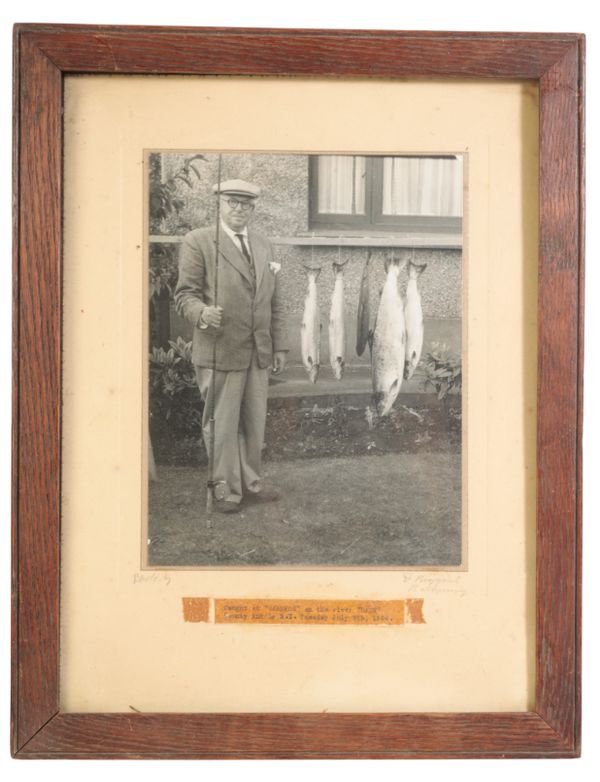 A BLACK AND WHITE PHOTOGRAPH OF A FISHERMAN WITH HIS CATCH