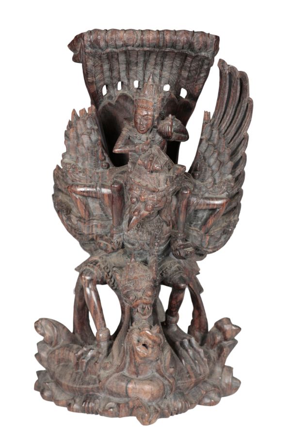 A SOUTH EAST ASIAN CARVED HARDWOOD GROUP OF VISHNU RIDING GARUDA