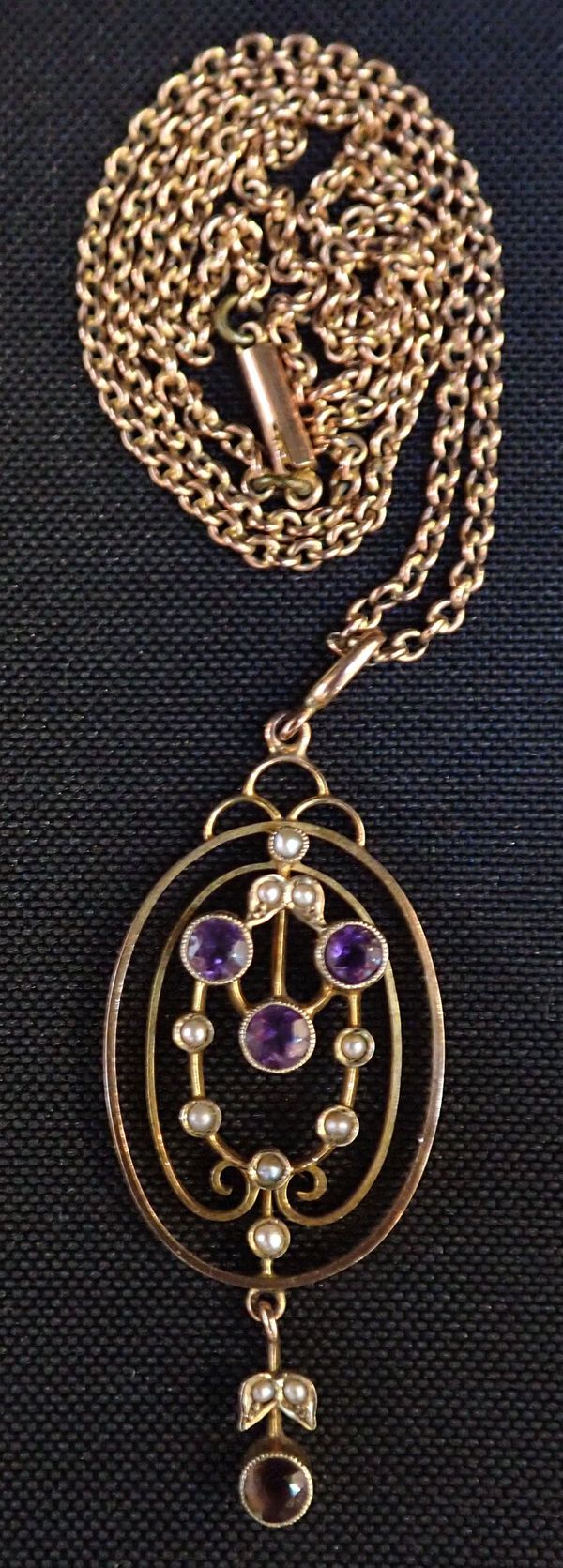 AN EDWARDIAN 9CT GOLD AMETHYST AND SEED PEARL OVAL PENDANT