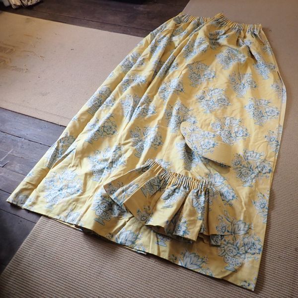 A PAIR OF YELLOW FABRIC CURTAINS