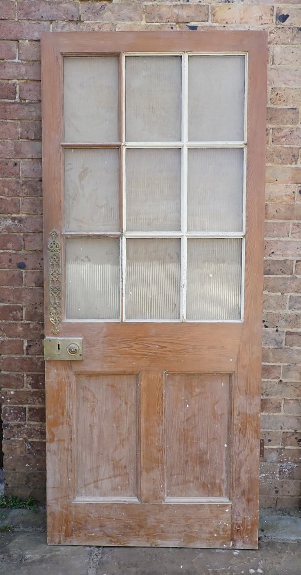 AN EARLY 19TH CENTURY PANELLED PINE PART GLAZED DOOR