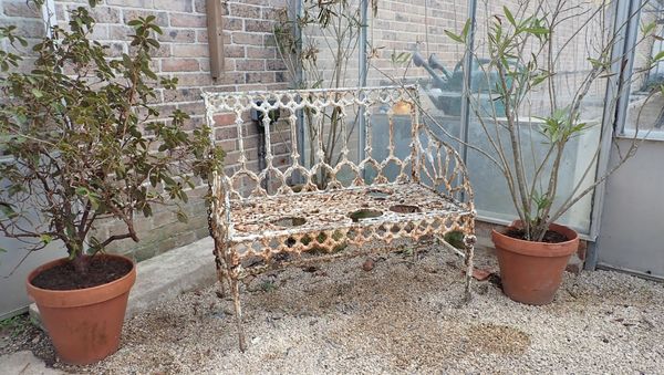 A WHITE PAINTED GARDEN BENCH OF 19TH CENTURY GOTHIC DESIGN
