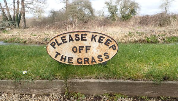 FIVE EARLY 20TH CENTURY PAINTED CAST IRON SIGNS - 'PLEASE KEEP OFF THE GRASS'