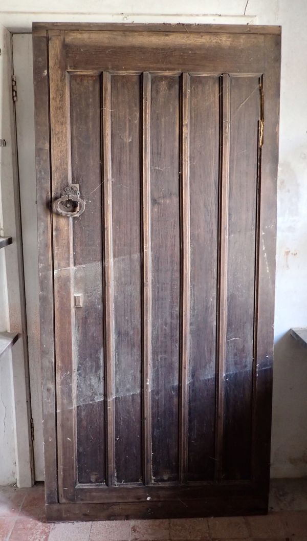 AN EARLY 20TH CENTURY PANELLED OAK DOOR