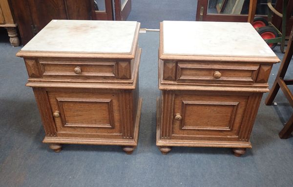 A PAIR OF MARBLE TOPPED OAK BEDSIDE CABINETS