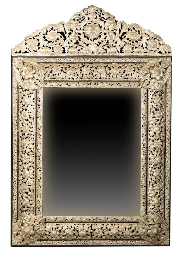 A CHARLES II STYLE REPOUSSE WHITE METAL AND EBONY MIRROR