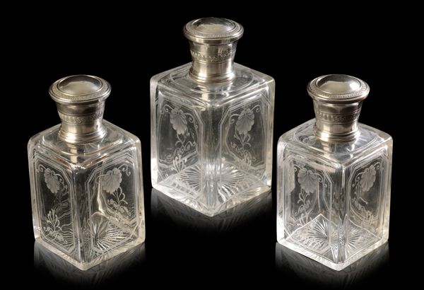 A GROUP OF THREE ENGRAVED CRYSTAL SILVER-TOPPED DRESSING TABLE BOTTLES