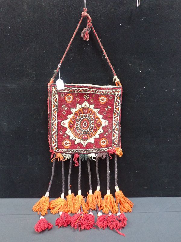 A SMALL CARPET BAG WITH LONG TASSELS