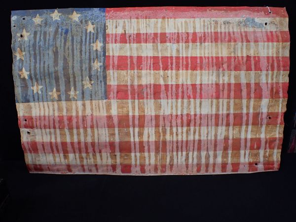 A CORRUGATED IRON SHEET, PAINTED WITH THE STARS AND STRIPES