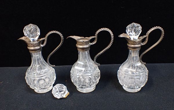 THREE MATCHING CONDIMENT BOTTLES WITH SILVER MOUNTS