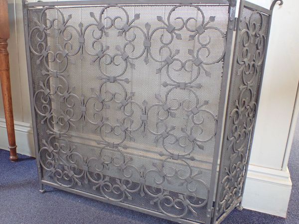 A WROUGHT IRON AND MESH FIRE SCREEN, OF TRIPTYCH FORM