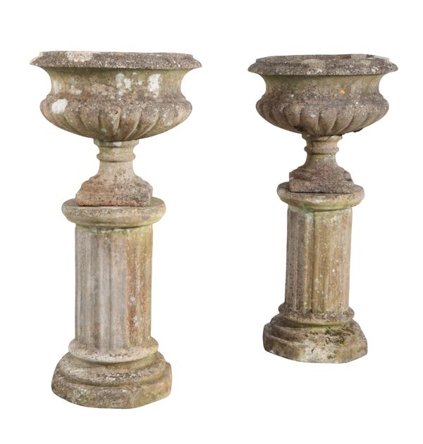 A PAIR OF RECONSTITUTED STONE URNS