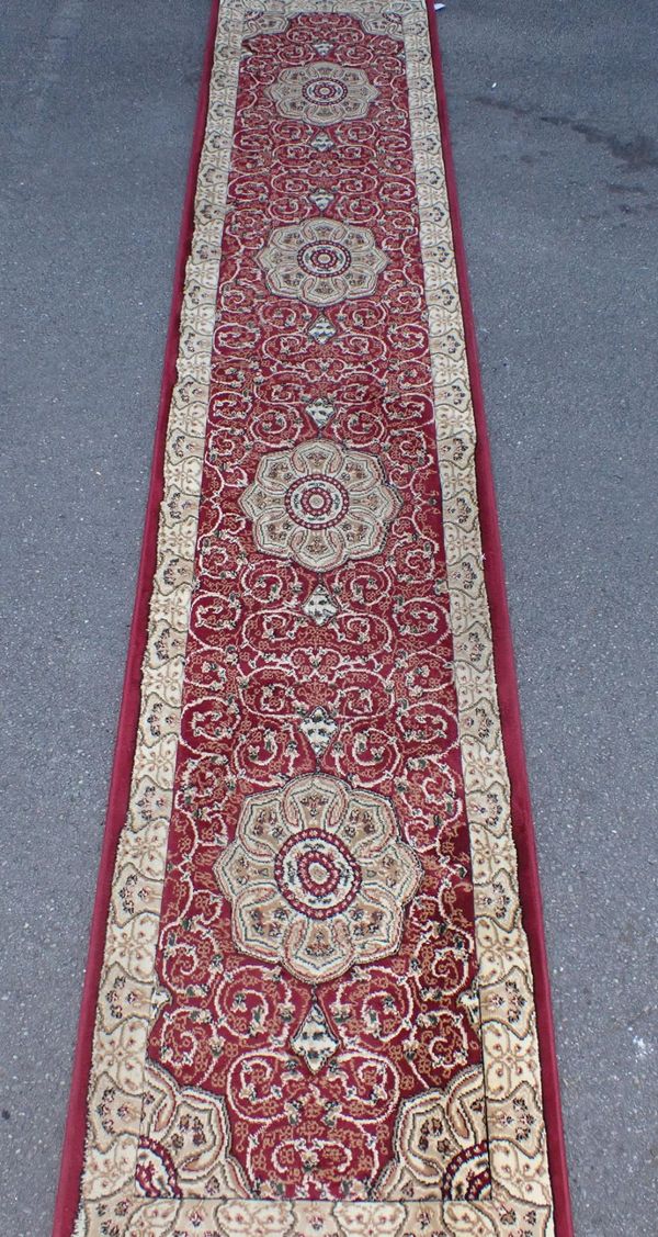 A MACHINE-MADE RED GROUND RUNNER