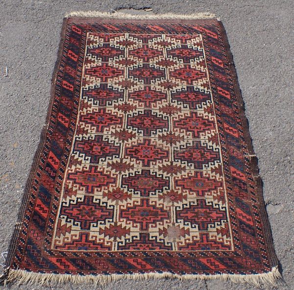 AN ANTIQUE BALUCH RUG