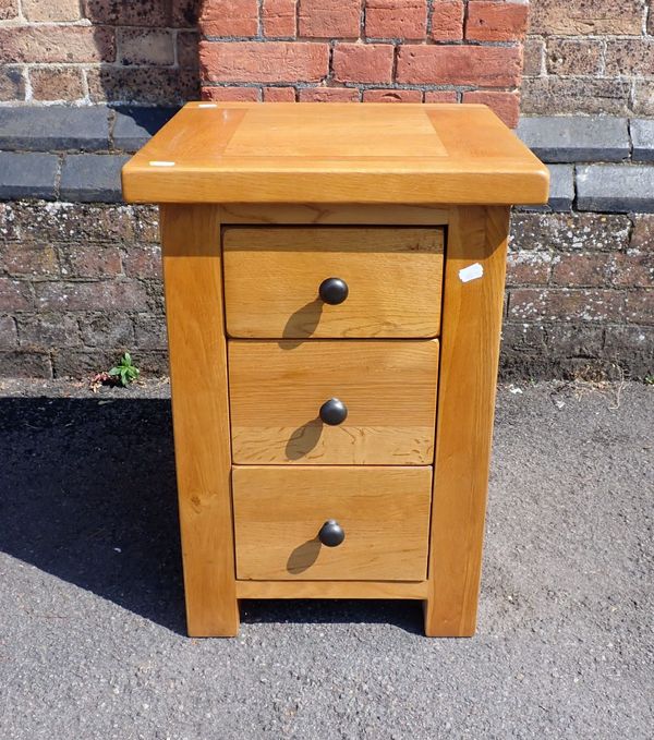 A MODERN THREE-DRAWER LIGHT OAK BEDSIDE CHEST