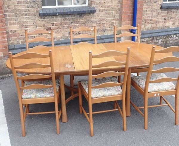 AN ERCOL ELM OVAL EXTENDING DINING TABLE