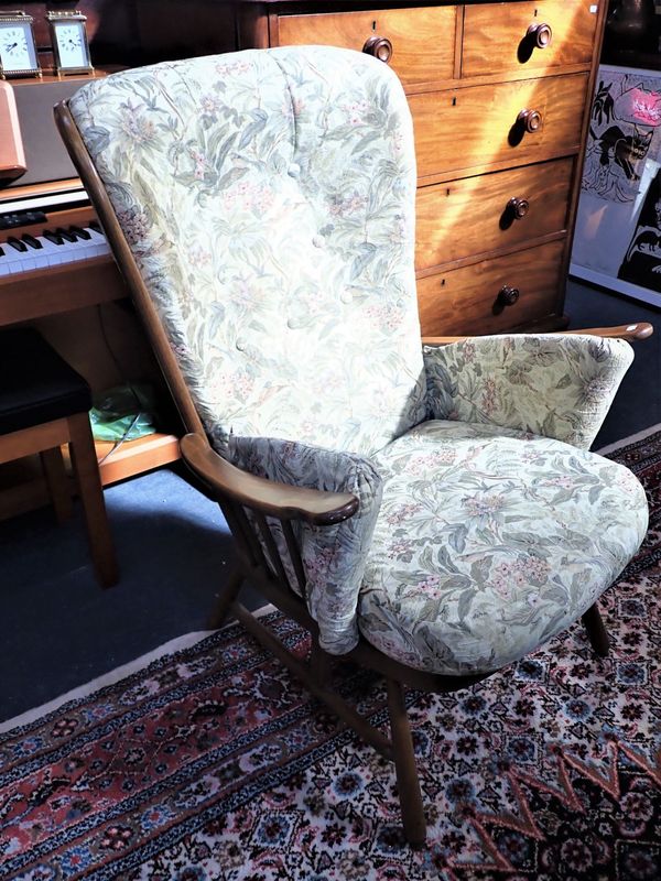 AN ERCOL ARMCHAIR, MID-BROWN STAINED BEECH