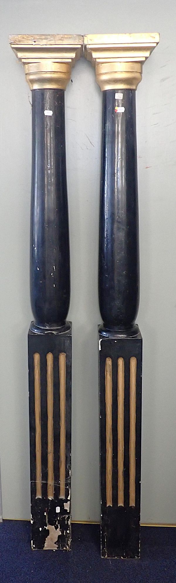 A PAIR OF EBONISED AND GILDED PILLARS