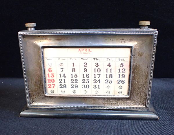 A SILVER-FRONTED DESK CALENDAR
