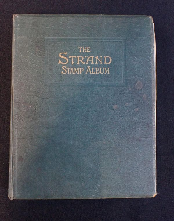 AN EARLY 20TH CENTURY ‘STRAND’ GREEN CLOTH STAMP ALBUM