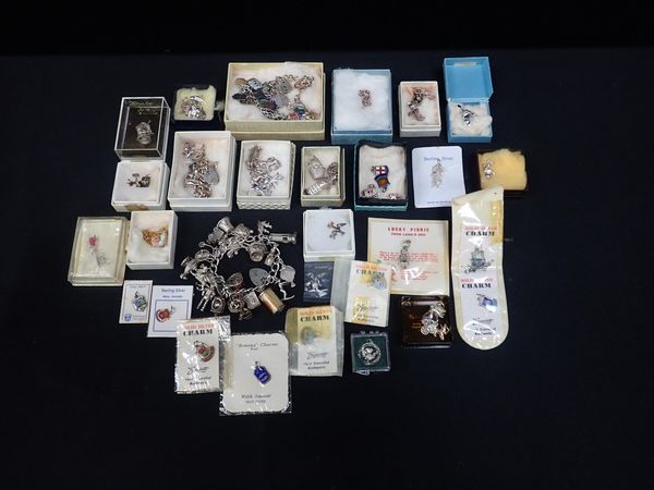 A COLLECTION OF SILVER AND WHITE METAL CHARMS