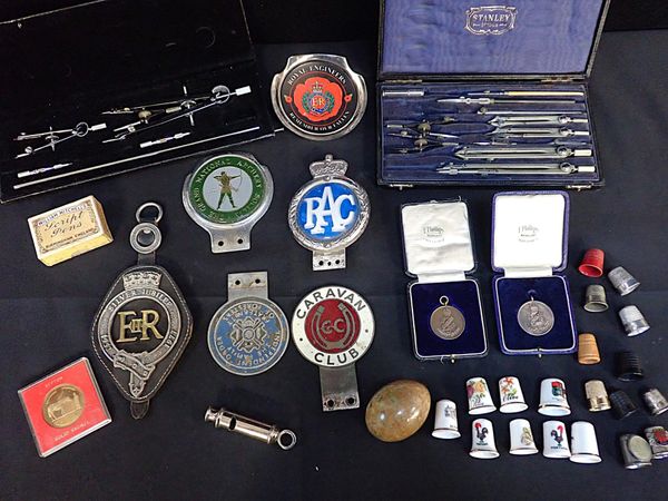 A COLLECTION OF CAR BADGES