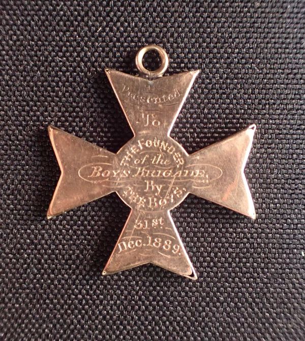 A YELLOW METAL CROSS; 'PRESENTED TO THE FOUNDER OF THE BOYS BRIGADE