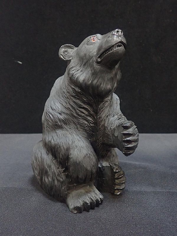 A CARVED FIGURE OF A SEATED BEAR