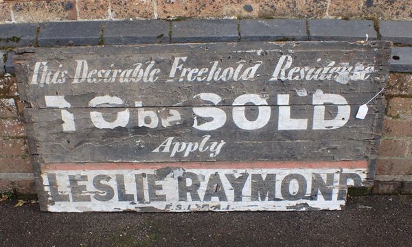 A PAINTED WOODEN ESTATE AGENT'S SIGN; LESLIE RAYMOND