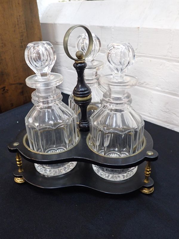 A 19TH CENTURY EBONISED WOOD AND BRASS MOUNTED THREE BOTTLE CRUET