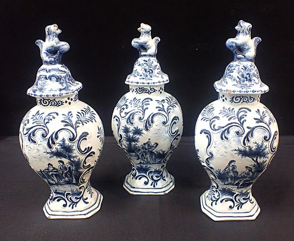 THREE DELFT GARNITURE VASES WITH COVERS