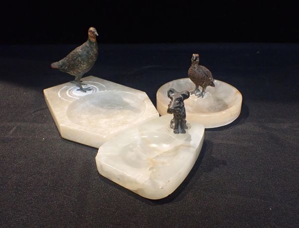 TWO ALABASTER AND ONE ONYX ASHTRAYS MOUNTED WITH BRONZE BIRDS AND A DOG