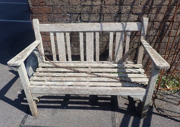 A WEATHERED TEAK GARDEN BENCH