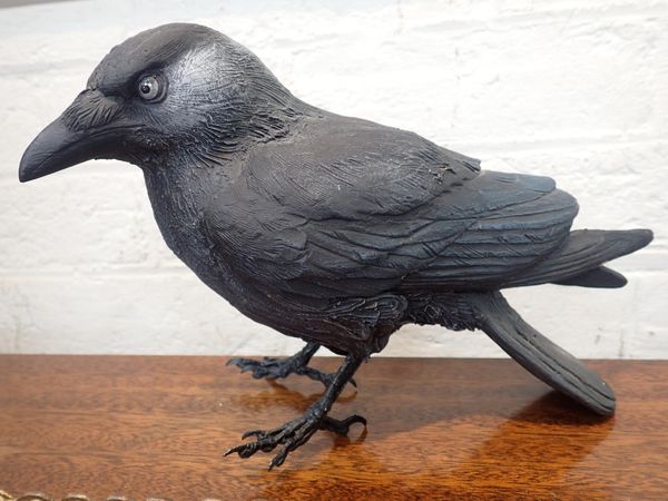 A METAL AND CERAMIC RAVEN SCULPTURE