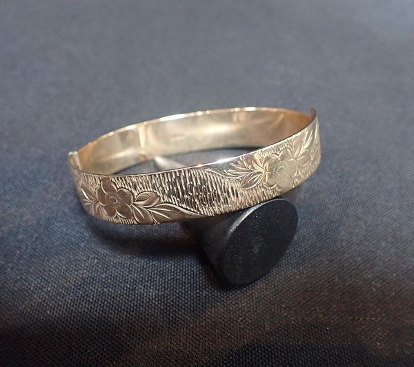A 9ct GOLD HINGED BANGLE