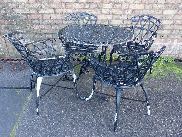 A CAST METAL GARDEN TABLE AND FOUR ARMCHAIRS