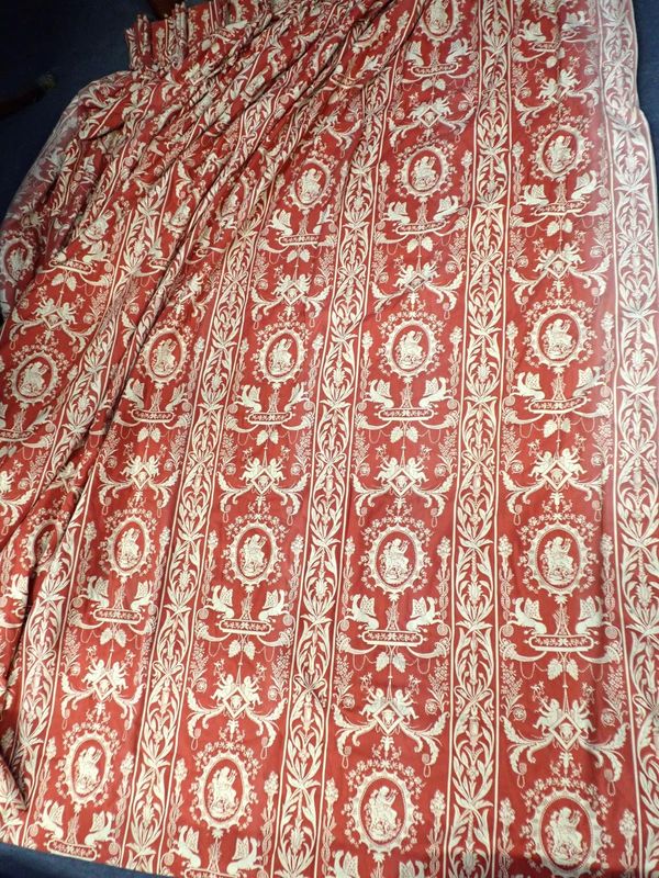 A PAIR OF ADAM STYLE CREAM AND RED GROUND LINED CURTAINS